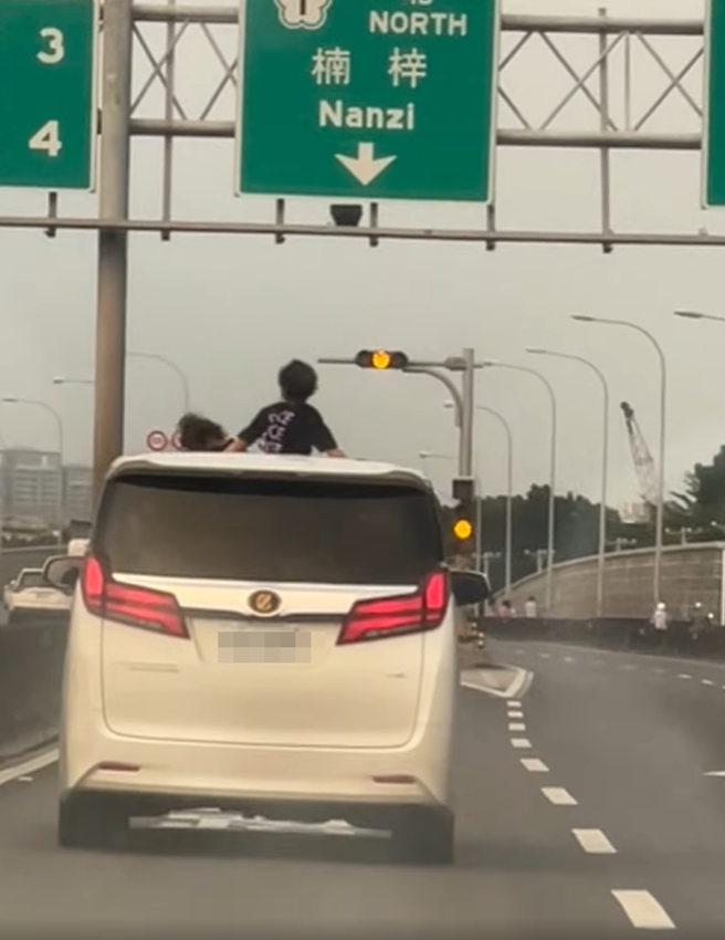 1名网友昨（2）在国道1号楠梓段发现前方轿车的天窗竟钻出2名幼童在吹风玩耍，11秒影片曝光引发眾怒，其他网友怒批家长失职。（翻摄自脸书「爆料公社公开版」）