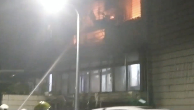 北市信义区吴兴街公寓狂窜火舌浓烟，屋主爬窗顺利逃生，警消救出29人。(台北市消防局提供)