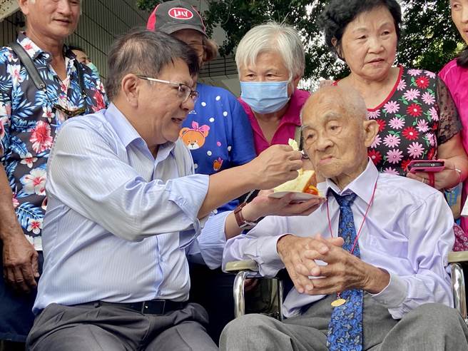 屏东县长潘孟安(左)喂长辈吃蛋糕，一同欢庆重阳节。(屏县府提供)