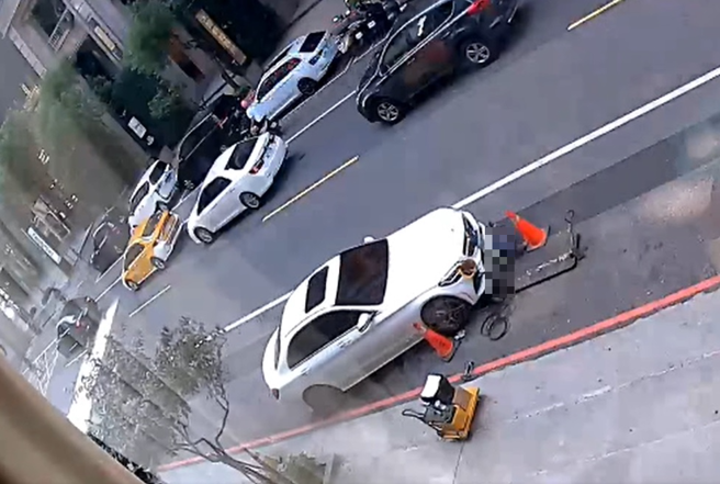 賓士女車主疑似未注意車前狀況，直接輾壓前方正坐在人孔蓋施工的工人。（翻攝自臉書報廢公社公開版）