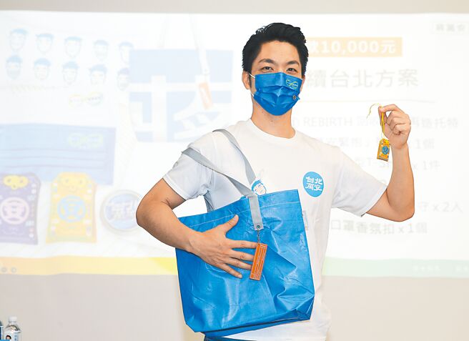 國民黨台北市長參選人蔣萬安直言，民進黨對台北市民的不公平對待、羞辱不是第一回，心裡只有政黨利益，沒有人民利益。圖為蔣萬安3日舉行競選官網、募款小物發布會，當起模特兒展示回收競選帆布再製的托特包及「台北萬安」祈福御守。（陳怡誠攝）
