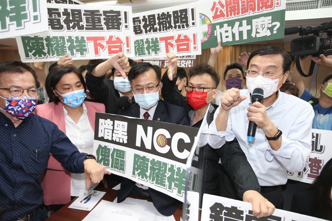立法院交通委员会邀请国家通讯传播委员会主任委员就「镜电视设置争议对国家通讯传播委员会独立公正性之影响」专题报告，国民党立委高举标语并要求NCC主委陈耀祥下台，陈则自备「请尊重独立机关」手牌回击。（姚志平摄）