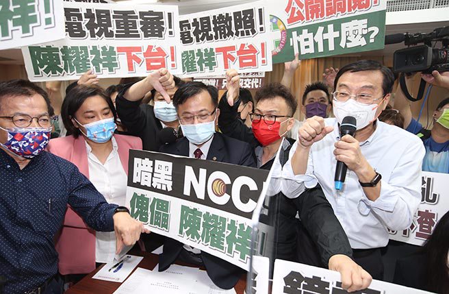 立法院交通委员会邀请国家通讯传播委员会主任委员就「镜电视设置争议对国家通讯传播委员会独立公正性之影响」专题报告，国民党立委高举标语并要求NCC主委陈耀祥下台，陈则自备「请尊重独立机关」手牌回击。（姚志平摄）