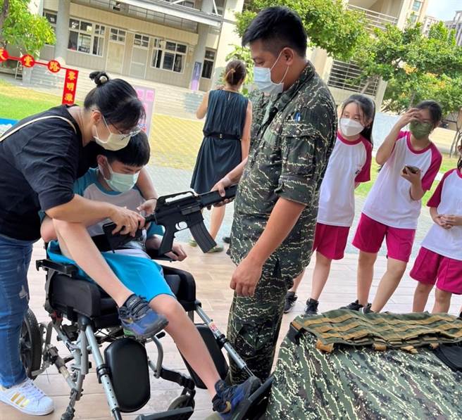 患有罕见疾病的林同学，5日也坐着电动轮椅随班一起参与活动，让林同学能拿起战斗步枪，体会国军保家卫国的使命。（高市教育局提供／杨舒婷高雄传真）