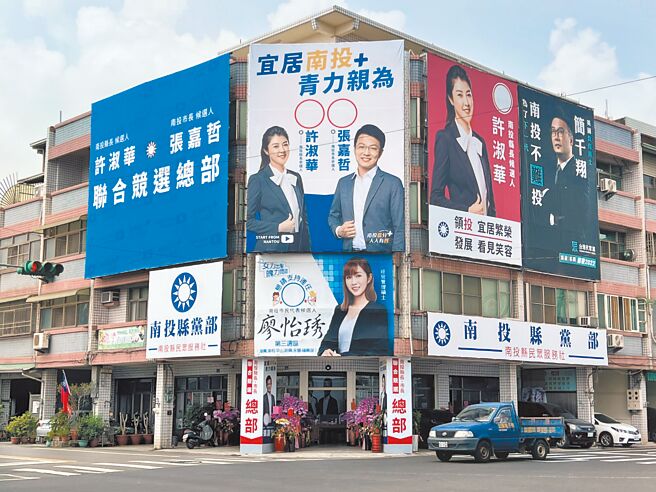 國民黨南投縣黨部外牆掛著國民黨籍參選人的競選看板及標語，藍中的一點白「民眾黨參選人簡千翔競選看板」格外引人注意。（民眾提供／楊靜茹南投傳真）