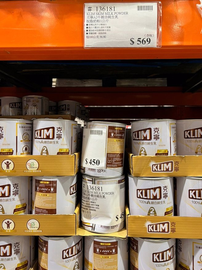 架上两罐奶粉外观已明显凹陷，还被贴上A4大小新的价表，上面盖有「包装破损」戳章。（图／翻摄自Costco好市多 商品经验老实说）