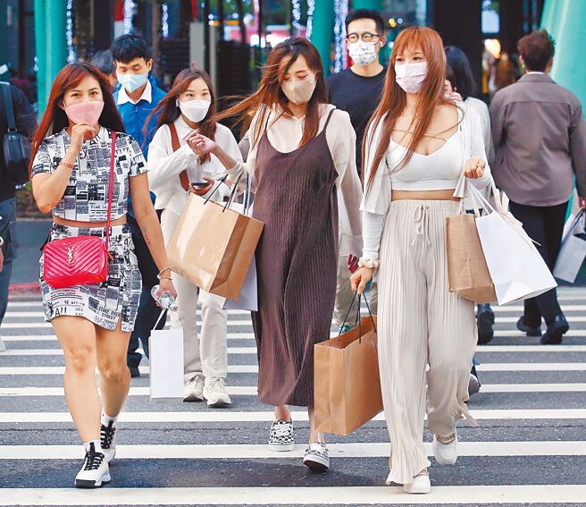 新冠肺炎确诊人数5日突破5万例，中央流行疫情指挥中心指挥官王必胜表示，现在应该就是疫情高峰，并处于疫情高原期波动。图为台北市区街头，逛街民眾紧紧地戴着口罩。（范扬光摄）