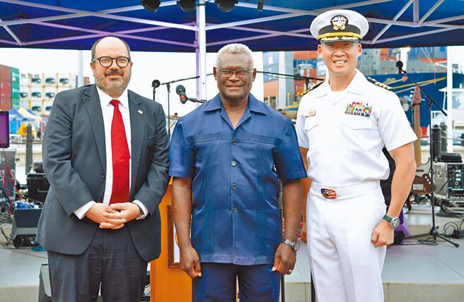 索羅門群島外長馬內萊（Jeremiah Manele）4日強調，索羅門不會在美國與中國之間選邊站。圖為2022年10月5日，美國駐索羅門群島臨時代辦Russ Comeau（左）、索羅門群島總理索加瓦雷（中）與太平洋夥伴關係2022任務指揮官金上尉（右）在霍尼亞拉市中心的團結廣場舉行的公共儀式上合影留念。（摘自美國印太司令部官網）