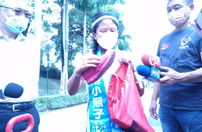 梁凱熙推著行李推車用雙腳走遍台灣各角落，她拿出自己走破的球鞋，表示已經走破4雙鞋子，雖然沿途很辛苦，但很開心，父母也很支持她。(林雅惠攝)