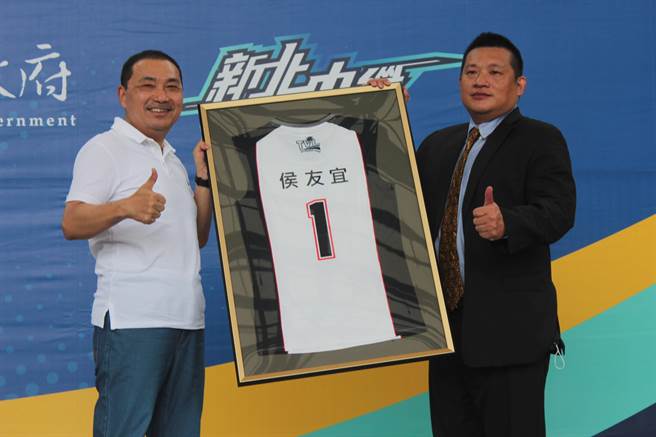 「新北中纤女子排球队」成军，中国人造纤维股份有限公司董事长王贵贤致赠全新冠名球衣给新北市长侯友宜（左）。（陈慰慈摄）