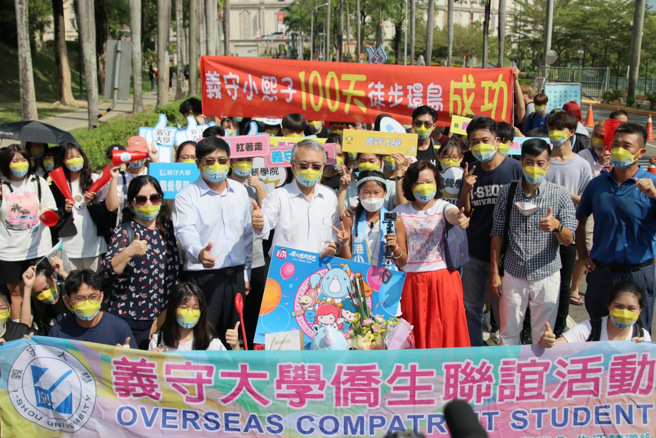 港生梁凯熙千里走全臺，第100天走回母校义守大学，师长与学弟妹们特别在校门口列队欢。(照片/义守大学提供)