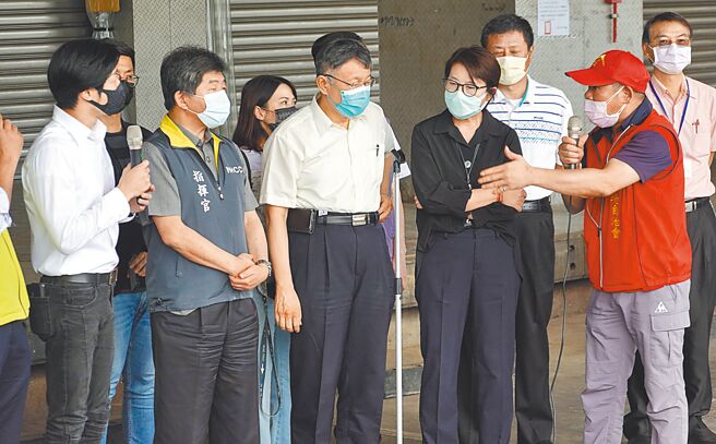 去年卫福部称「万华是防疫破口」，环南市场自治会长林胜东（右）日前不满地说「揍一顿再道歉，你会接受吗？」陈时中（左二）昨天回称，「觉得有痛可以跟我讲」。图为2021年7月时任疫情指挥中心指挥官陈时中、台北市长柯文哲（右三）与林胜东在环南市场视察疫情。（本报资料照片）