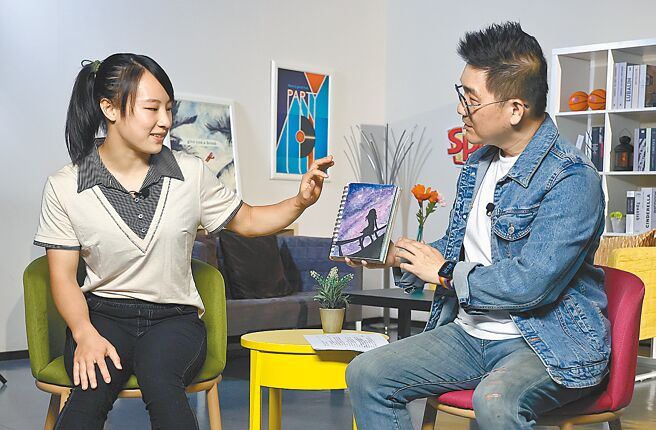 体操国手丁华恬（左）在《Sports会客室》节目中接受主持人李弘斌访问，并展示亲笔画作。（范扬光摄）