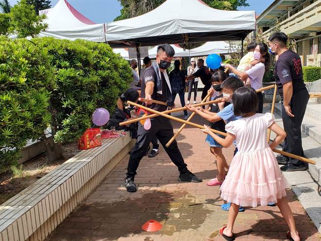 木棍是七崁武術的兵器之一，小朋友們嘗試用木棍瞄準水球，體驗出力的感覺。（周麗蘭攝）
