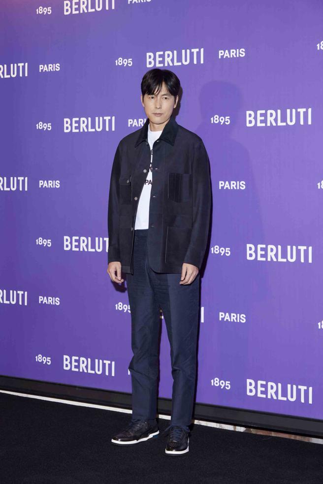 鄭雨盛以Berluti冷夜藍 Workwear 絨面皮革外套25萬9000元、冷夜藍棉質西裝褲2萬7900元、白底黑色logo T-Shirt 2萬700元、Playoff 黑色低筒運動鞋 6萬9000元亮相。（Berluti提供）