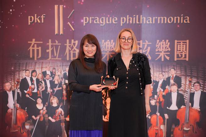 布拉格爱乐管弦乐团将首次造访屏东，屏东县文化处副处长李昀芳（左）也亲自北上赠送团长凯特琳娜原住民琉璃手炼，要让团长凯特琳娜（右）把满满的台湾味带回捷克。（宽宏艺术提供）