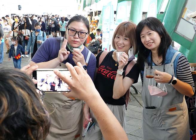 逛「商圈嘉年华-台北生活祭」活动的民眾在摊位前开心地合影。（姚志平摄）  