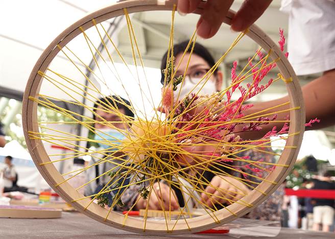  在「商圈嘉年华-台北生活祭」活动中，民眾热情参与手作体验课程，在老师讲解下专心制作花卉捕梦网。（姚志平摄）   