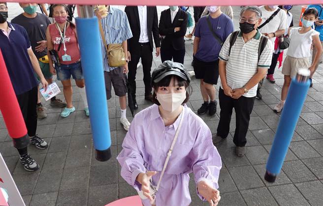 在「商圈嘉年华-台北生活祭」活动中，民眾在游戏区体验趣味游戏机台，尝试接住随机掉落的棒子测试反应。（姚志平摄）