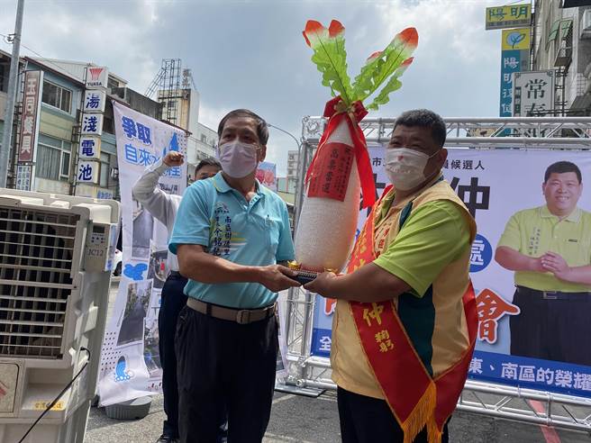 台中市南区里长联谊会长余铭记（左）当场致赠「好彩头」，期盼高票当选。（张妍溱摄）