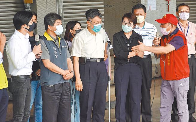 去年卫福部称「万华是防疫破口」，环南市场自治会长林胜东（右）日前不满地说「揍一顿再道歉，你会接受吗？」陈时中（左二）昨天回称，「觉得有痛可以跟我讲」。图为2021年7月时任疫情指挥中心指挥官陈时中、台北市长柯文哲（右三）与林胜东在环南市场视察疫情。（本报资料照片）