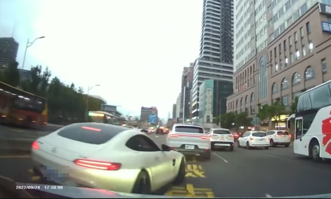 驾驶行驶在忠孝西路，遭到1辆宾士车突然强行从左侧插入前方，宾士车接着还不断逼车、拦停，宾士车主等红灯时直接开车门，下车走向后方谯三字经。（翻摄自YouTube）