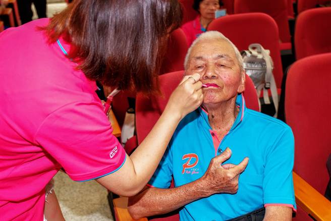 艺人田馥甄外公的宋增土爱跳舞，喜欢化妆打扮漂漂亮亮参加比赛，2019年在竹县阿公阿婆活力秀竞赛前，协会人员帮他化妆上唇膏。（罗浚滨摄）