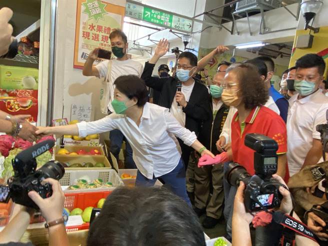 卢秀燕与建国市场摊商话家常，展现亲和力。（张妍溱摄）