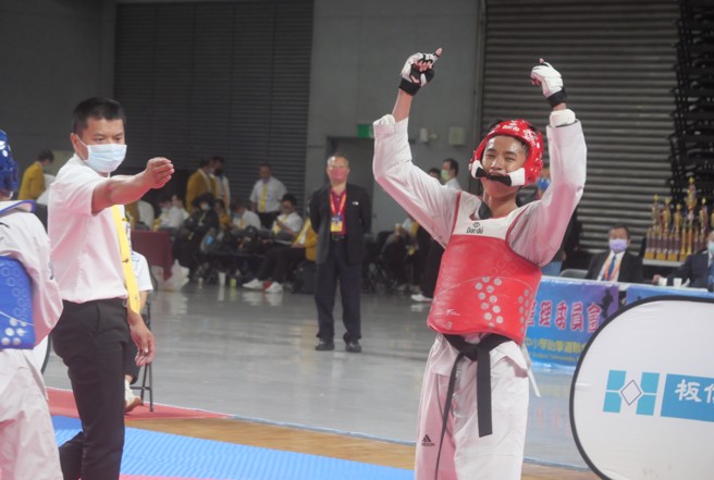 萬芳高中跆拳道好手柯翔瀚（右），在110學年全中錦高男63公斤級決賽摘金，開心大吼慶祝。（大會提供）