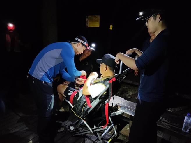 许姓男子于波津加山步道右脚足踝扭伤无法行走，消防人员以人工背负及搬运椅方式下撤至登山口。（台中市消防局提供）