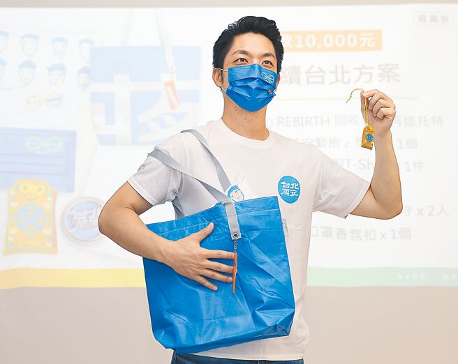 国民党台北市长参选人蒋万安3日举行竞选官网、募款小物发布会，蒋万安（见图）当起模特儿展示回收竞选帆布再制的托特包及「台北万安」祈福御守。（陈怡诚摄）