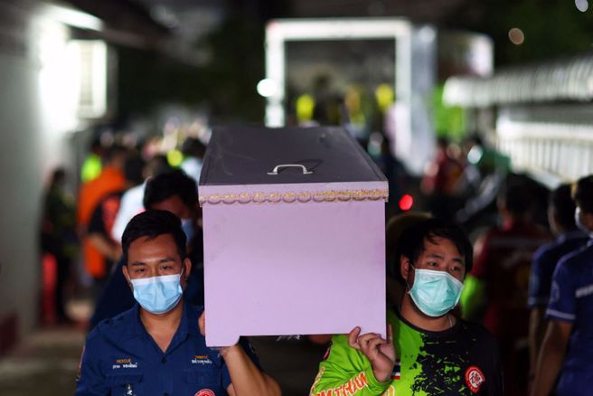 工作人员正从托儿所内搬出一些粉红色棺材，里面装着受害儿童的尸体，准备运往当地一家医院。 (图/路透社)