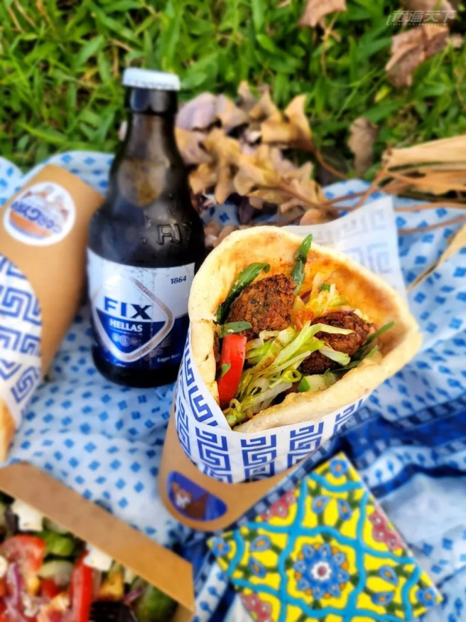 FALAFEL GYROS鹰嘴豆球卷(素/含葱蒜奶) / 135元。在欧洲十分流行的蔬食卷，满满的新鲜蔬菜搭配地中海香料鹰嘴豆球和鹰嘴豆泥酱，吃得到芝麻叶的辛香。希腊啤酒Fix/135元。源自1864年的FIX希腊传统顶级拉格啤酒累积150年的酿酒经验，口感滑顺，带有清新的苹果、香蕉香气。（未成年请勿饮酒。开车不喝酒，喝酒不开车！）（图/ 行遍天下）