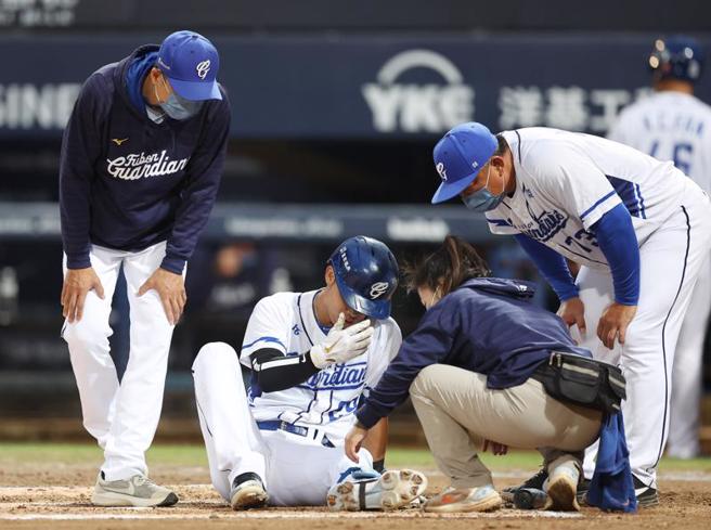 富邦悍将申皓玮（左2）首局上场打击，却因自打球倒地久久无法站起，防护员（右2）与总教练丘昌荣（左）上场关心，随后让申皓玮退场治疗。（中央社）