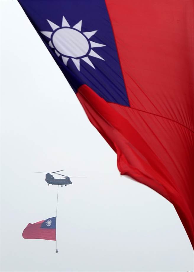 中华民国各界庆祝111年国庆大会10日在总统府前登场，国歌领唱时，陆航CH-47SD契努克运输直升机吊挂巨幅国旗通过观礼台。（黄世麒摄）