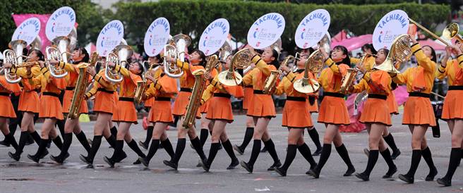 中华民国各界庆祝111年国庆大会10日在总统府前登场，应邀来台表演，有「橘色恶魔」之称的日本京都橘高等学校吹奏乐部学生，以边吹边跳方式，融入活泼的舞蹈，整齐画一的步伐及队形令人印象深刻，深受台湾民眾喜爱，所到之处刮起一阵「橘色旋风」。（黄世麒摄）