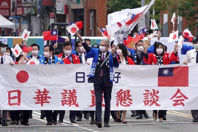 中华民国各界庆祝111年国庆大会10日在总统府前登场，日华议员恳谈会由会长古屋圭司（中）率领，手持日本及我国国旗进场。（黄世麒摄）