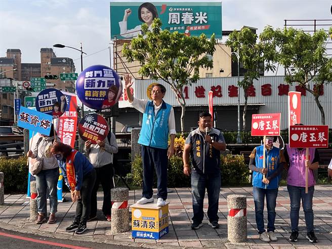 蓝营屏东县长参选人苏清泉11日特地站在挂有劲敌周春米大型看板的路口拜票，狠酸对方花大钱买文宣。（谢佳潾摄）