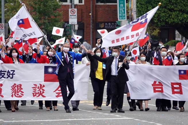 中華民國各界慶祝111年國慶大會10日在總統府前登場，日華議員懇談會由會長古屋圭司（前排左）率領，與我國立法院副院長蔡其昌（前排右）率領的台日交流聯誼會成員，手持兩國國旗一同進場。（中時資料照，黃世麒攝）