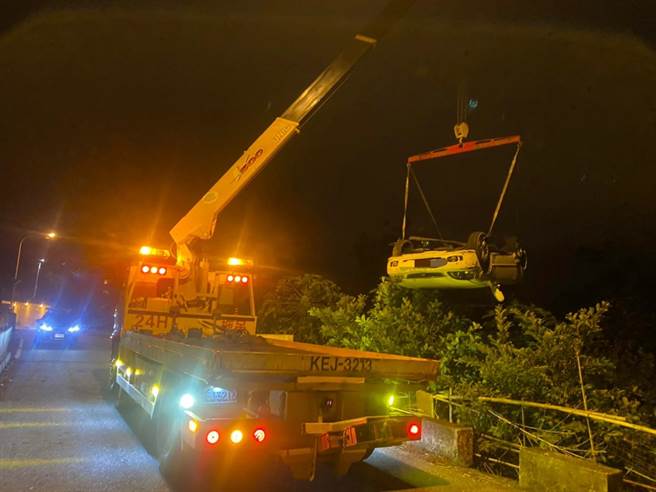 涉嫌闯红灯、衝撞员警，自小客车摔落草丛，警方将车辆吊起搜证。（新城警分局提供）