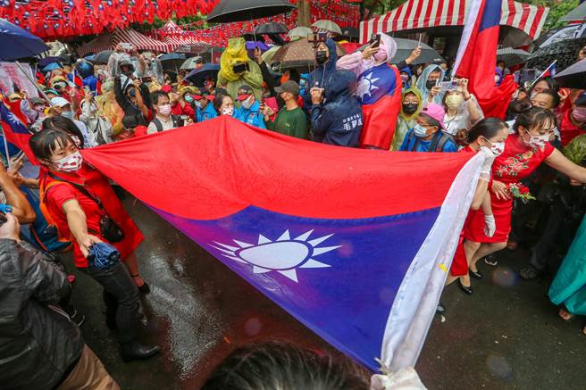 桃园平镇区国旗屋老板张老旺，依往例在双十国庆当日，于云南文化公园举办第28次国庆升旗典礼，巨型国旗从中央进场，台上人员迎接国旗准备升旗。（陈麒全摄）