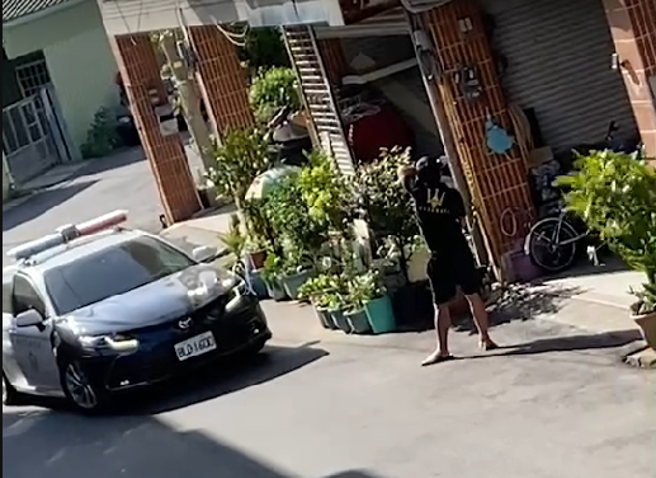 李姓男子双手持菜刀在住家附近路上不断挥舞，警方获报后赶到现场，趁隙将李男手中菜刀击落后，一度在地上扭打，最后顺利压制。(记者爆料网提供)