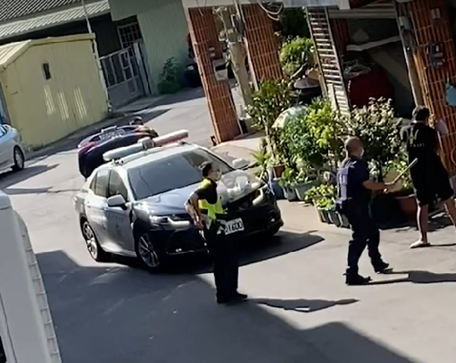 李姓男子双手持菜刀在住家附近路上不断挥舞，警方获报后赶到现场，趁隙将李男手中菜刀击落后，一度在地上扭打，最后顺利压制。(记者爆料网提供)