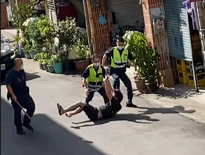 李姓男子双手持菜刀在住家附近路上不断挥舞，警方获报后赶到现场，趁隙将李男手中菜刀击落后，一度在地上扭打，最后顺利压制。(记者爆料网提供)