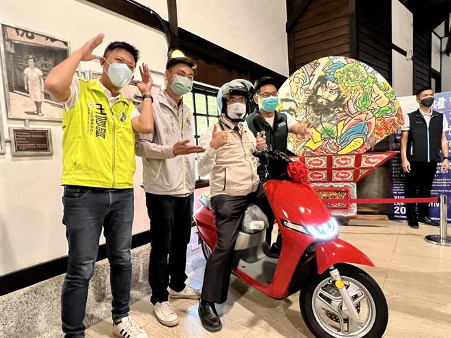 台南市长黄伟哲（右二）12日宣传盐水嘉年华，还特别戴上安全帽，骑着此次「集章摸彩」活动中最大奖6万元的电动机车进场。（张毓翎摄）