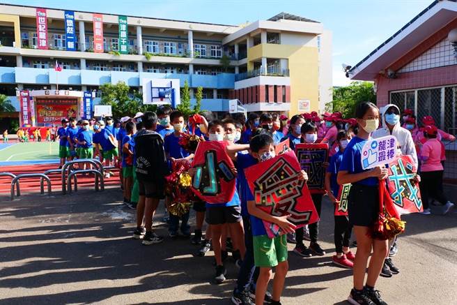 台中龍井區龍津國小師生12日於學區內舉辦「百人踩街賀龍津」活動，師生高舉標語彩球邀請社區民眾一起參與學校15日舉辦百年校慶活動。（龍津國小提供／馮惠宜台中傳真）