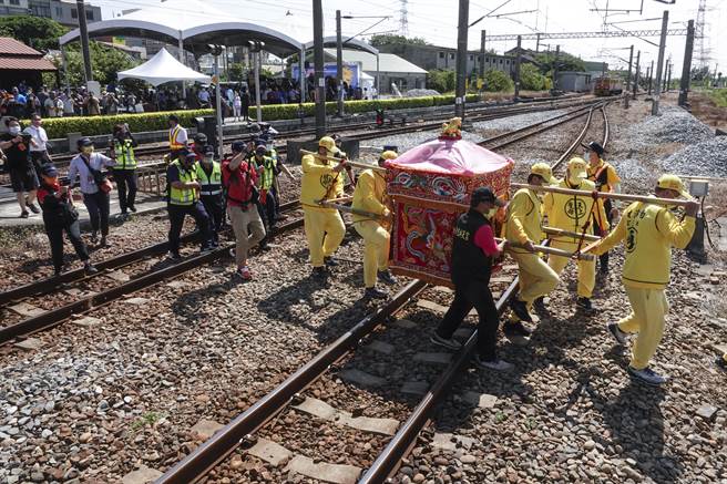 白沙屯妈祖銮轿由轿班扛着走过铁轨进到第二月台。（黄子明摄）