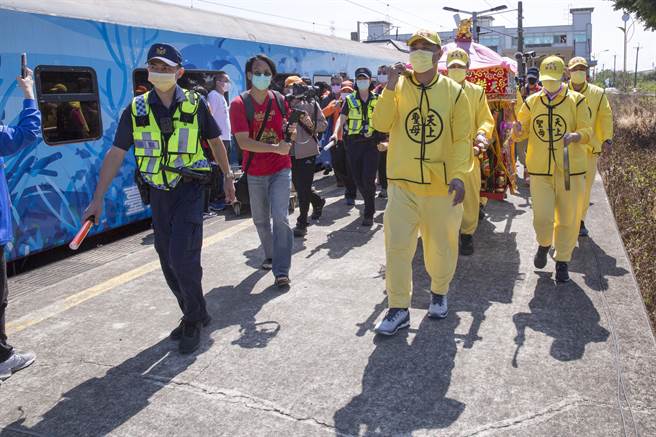 DT668蒸汽火车约12点抵达通霄车站，休息整补一个小时后，妈祖銮轿由轿班扛着走过铁轨进到第二月台。（黄子明摄）