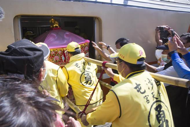 DT668蒸汽火车约12点抵达通霄车站，休息整补一个小时后，妈祖銮轿由轿班扛着走过铁轨进到第二月台，在大批信徒簇拥下登上第一节车厢。（黄子明摄）