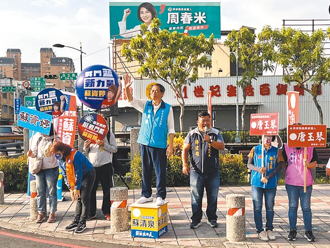 蓝营屏东县长参选人苏清泉（中）11日站在挂有劲敌周春米大型看板的路口拜票，狠酸对方花大钱买文宣。（谢佳潾摄）